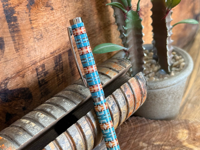 Close-up of turquoise Aztec-pattern ballpoint pen with silver metal cap
