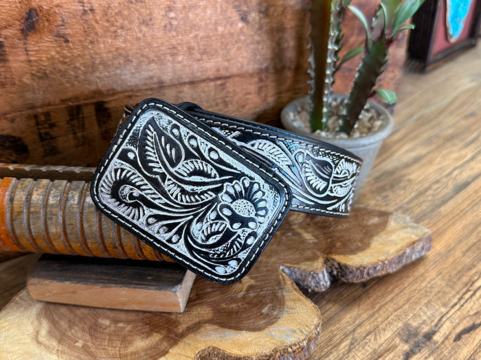 Black tooled cowhide belt with ornate floral tooling and dark metal buckle