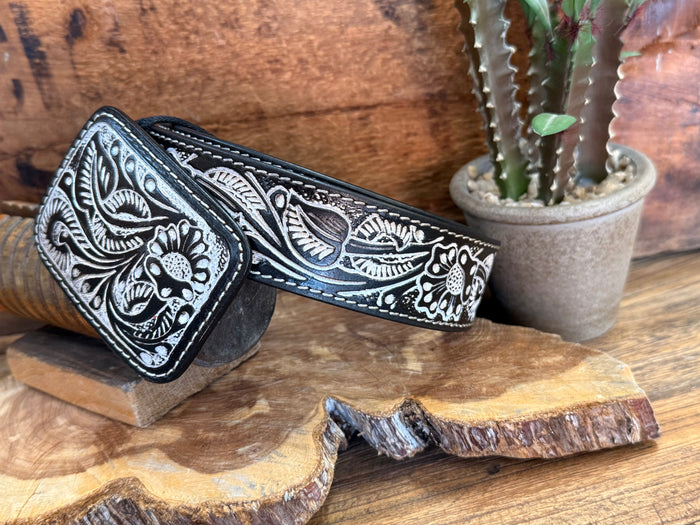 Black tooled cowhide belt with carved floral motifs and adjustable strap