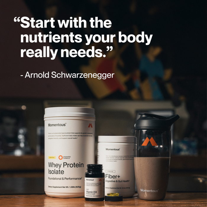 "Start with the nutrients your body really needs." – Arnold Schwarzenegger. Four Momentous products on a table: Whey Protein Isolate Vanilla, Vitamin D3, Fiber+ Unflavored, and a Momentous shaker bottle.