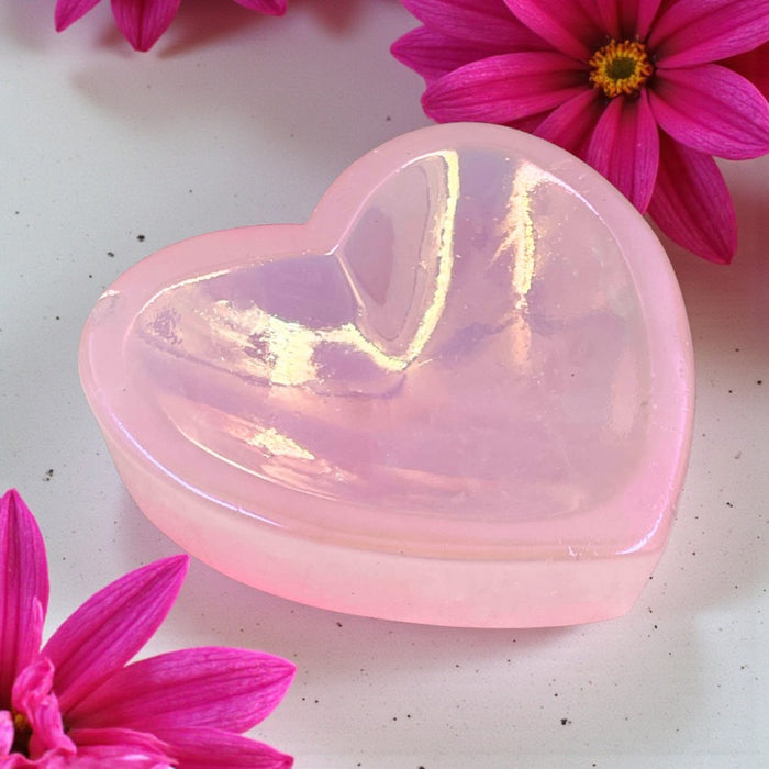 Aura Rose Quartz Heart Trinket Dish on a white surface with pink flowers.