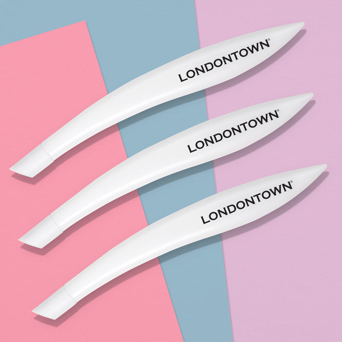 Three white cuticle pushers with the "LONDONTOWN" brand name printed on them are arranged diagonally on a background of pink, blue, and purple triangles, perfect for achieving salon-quality manicure results.