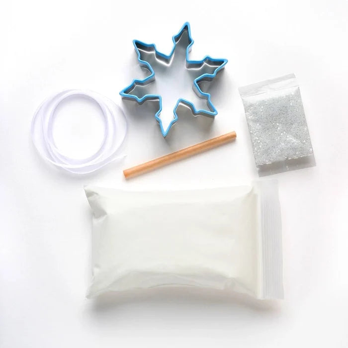 Cookie cutter, wooden stick, and small container on a white background