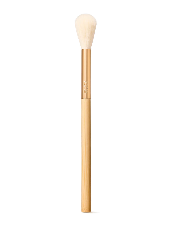 Tarte blush makeup brush with wooden handle and white bristle head on a white background