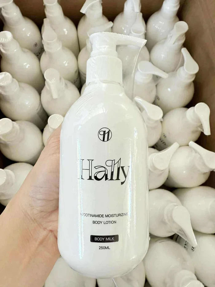 Hand holding Hally Niacinamide Moisturizing Body Lotion bottle, 250ml, surrounded by similar white bottles