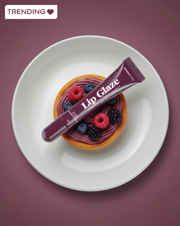 Lip Glaze product on a dessert with berries on a white plate against a purple background