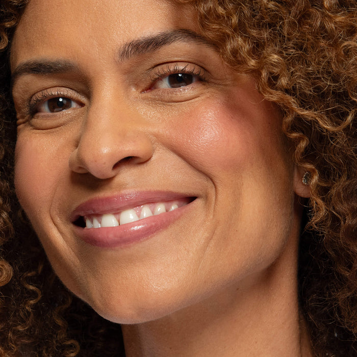 No Makeup Makeup – Close-up of a tanned skin woman wearing pink blush on cheeks and lips, natural minimal makeup