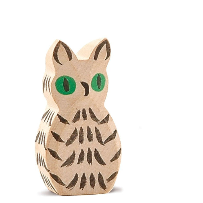 White wooden owl figurine with green eyes on a white background