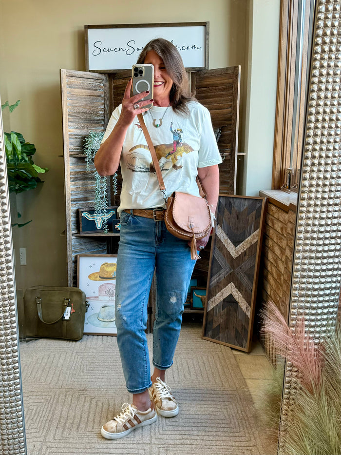 Light blue T-shirt with cowboy dinosaur graphic, short sleeves and crew neckline