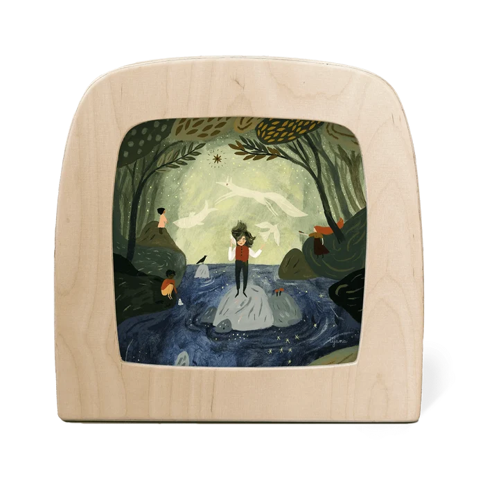 Wooden frame with a painted scene of a person standing on a rock in a forest.
