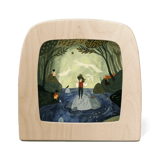Wooden frame with a painted scene of a person standing on a rock in a forest.