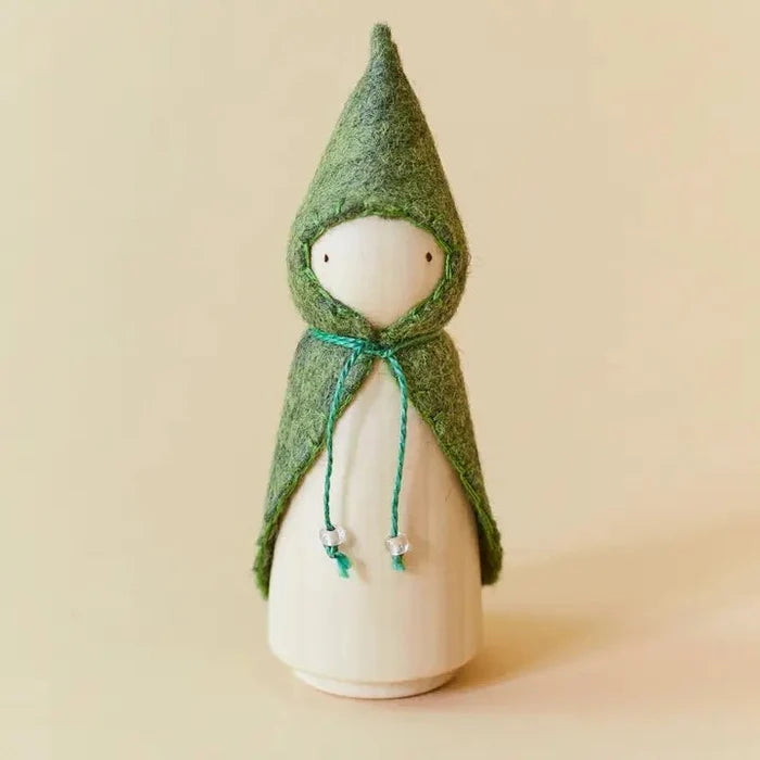 Wooden gnome figure with a green hood and coat on a beige background