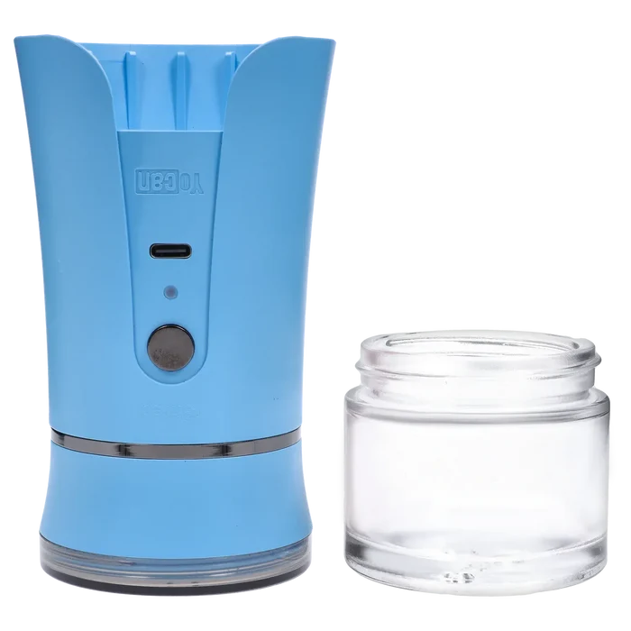 Close-up front view of the blue Yocan iShred Electronic Grinder showing its USB-C port, round button, and a clear glass jar beside it.